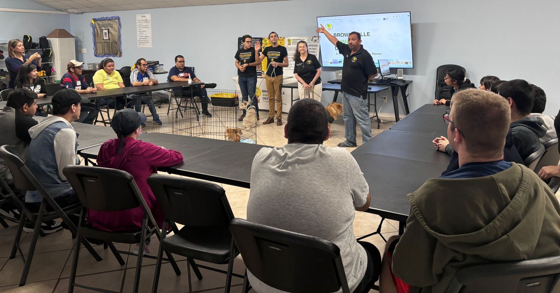 A group of people are sitting around a table in a room.