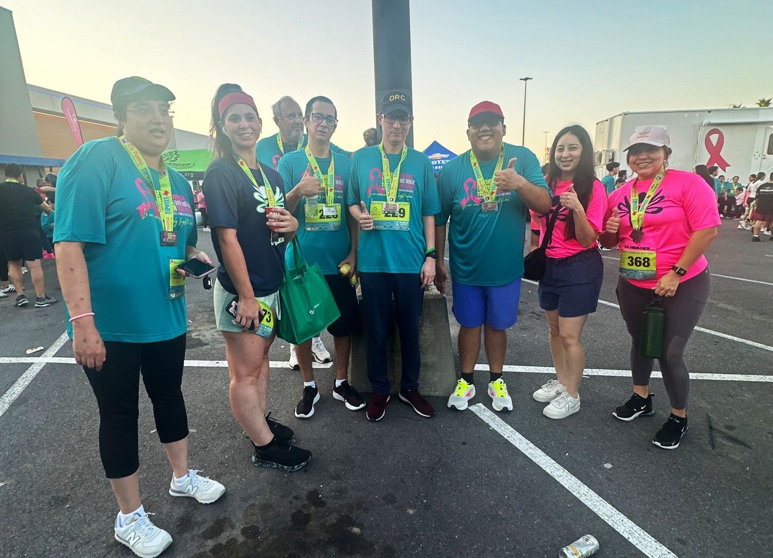 A group of people are posing for a picture in a parking lot.