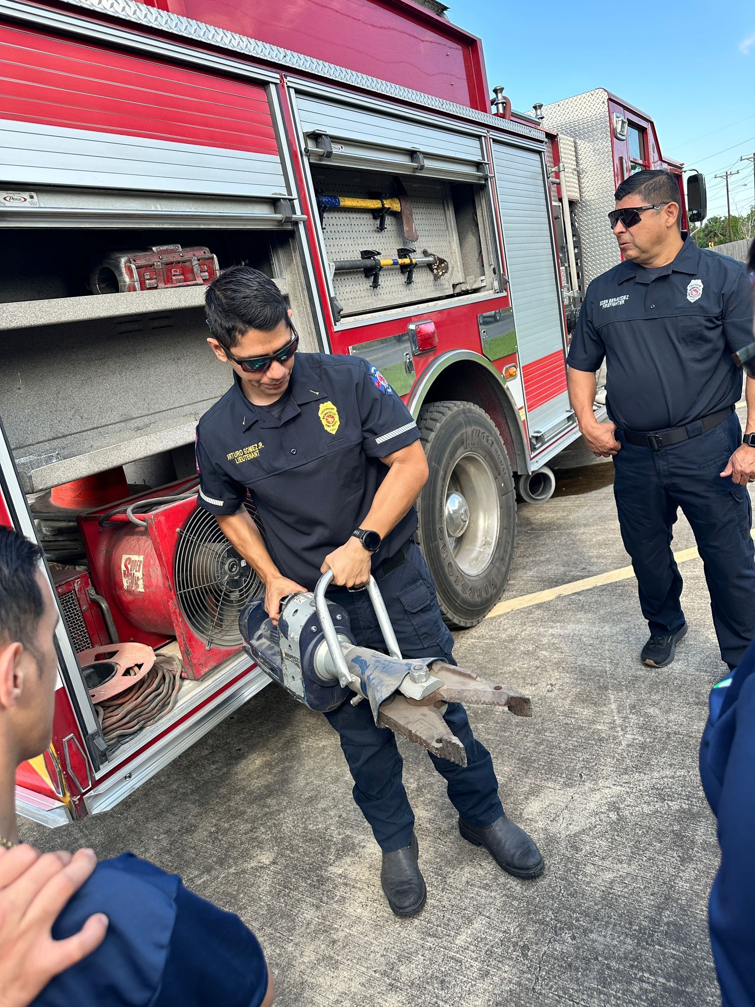 A group of firefighters are standing next to a fire truck.