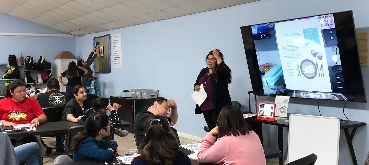 A woman is giving a presentation to a group of people in a room.