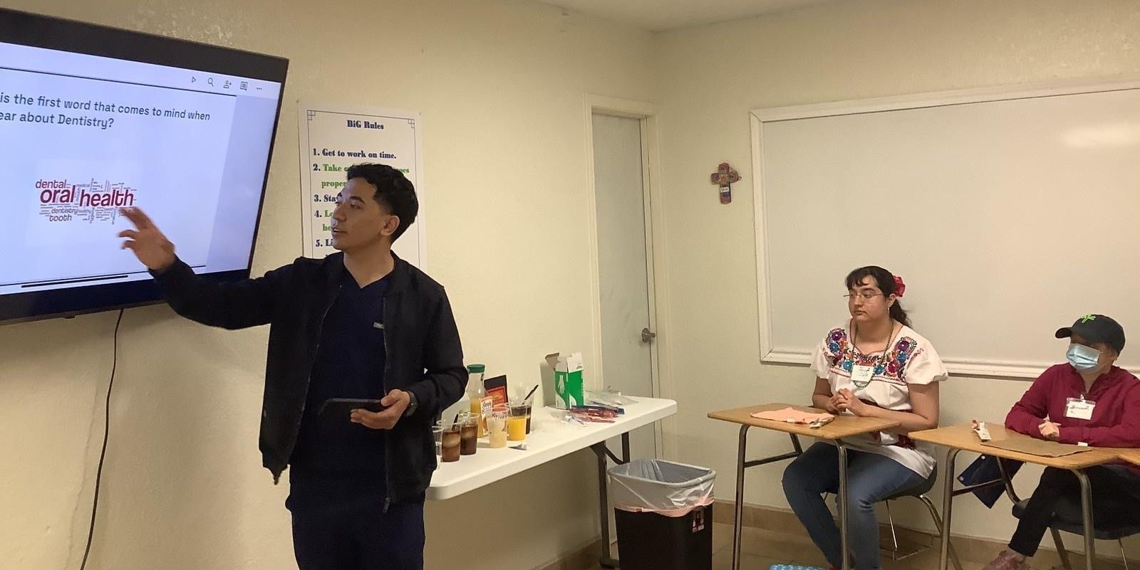 A man is giving a presentation in front of a group of people in a classroom.