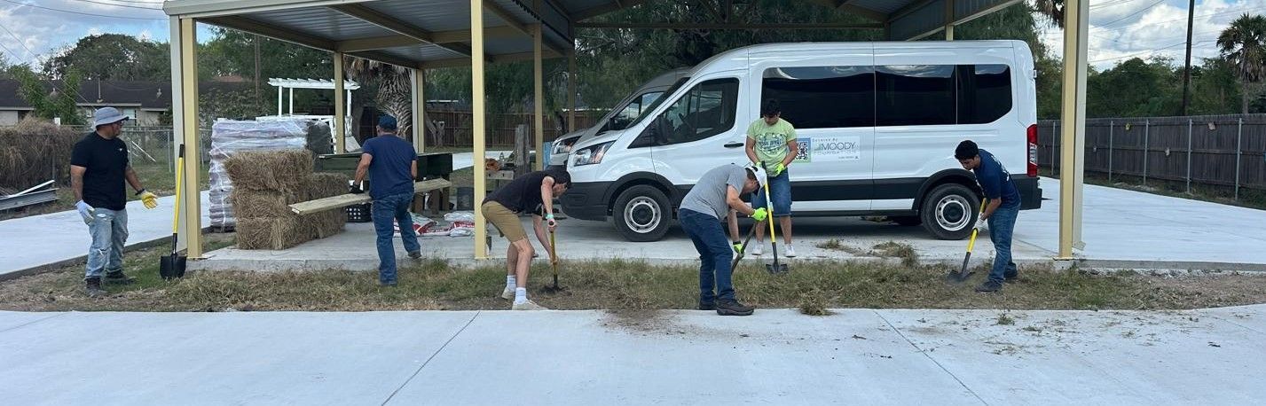 A group of people are working in front of a white van.