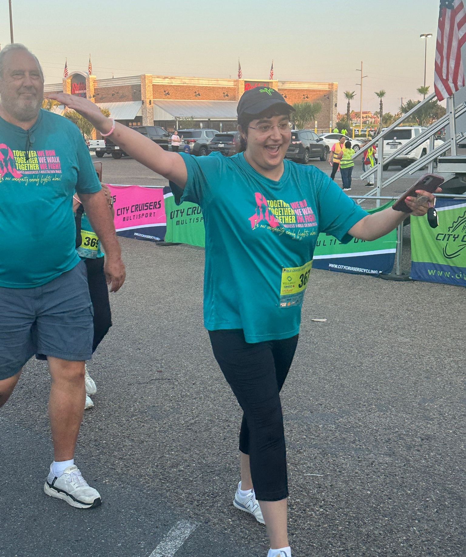 A man and a woman are running in a parking lot
