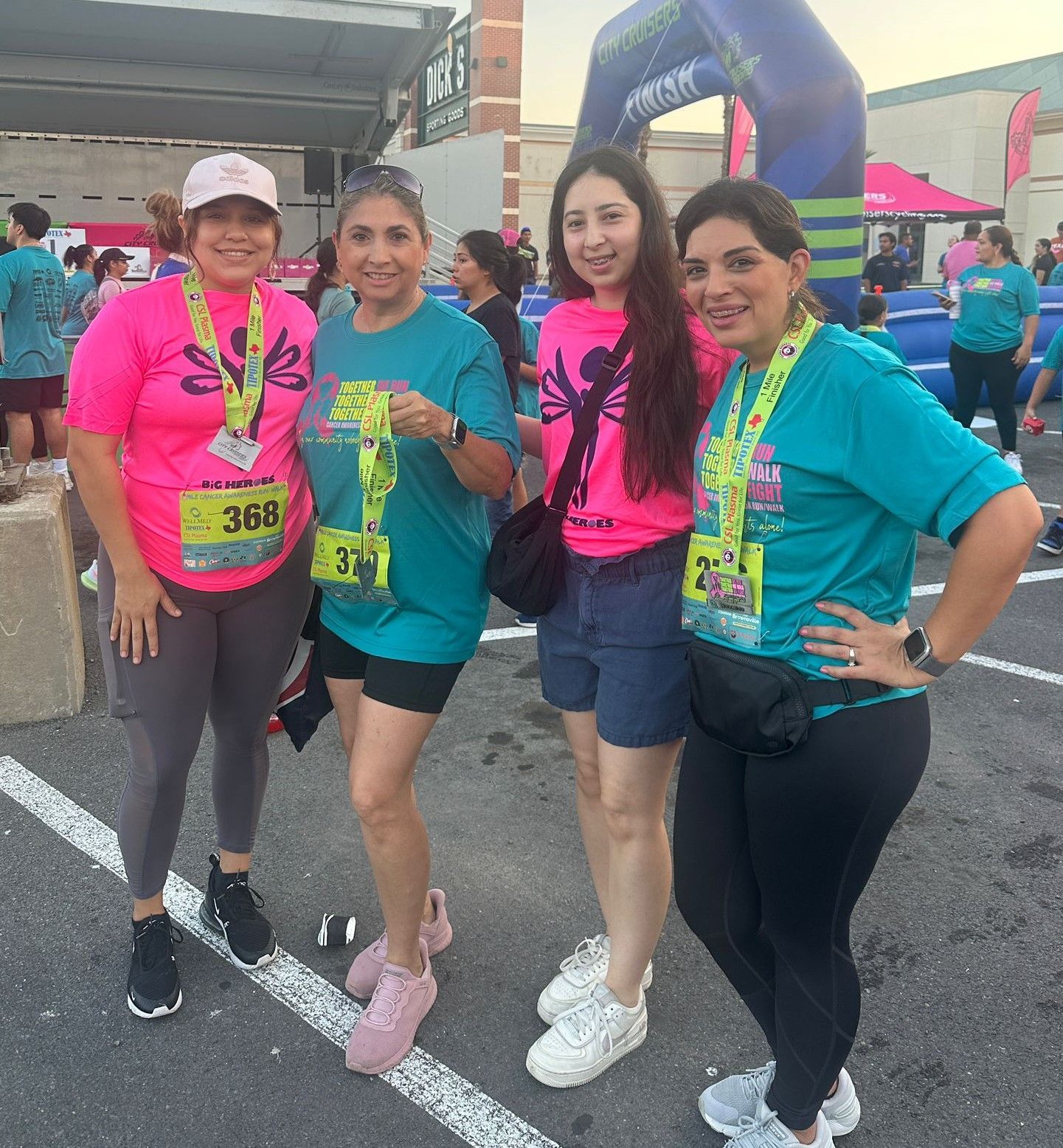 A group of women are posing for a picture in a parking lot