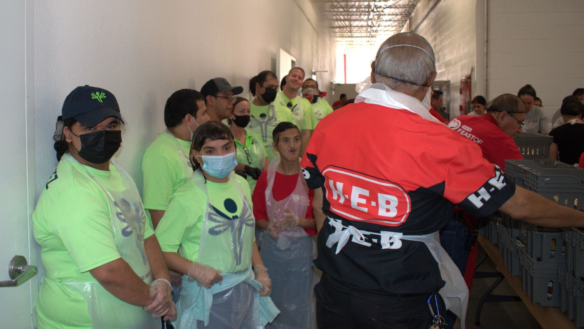 A group of people wearing masks are standing in a hallway.