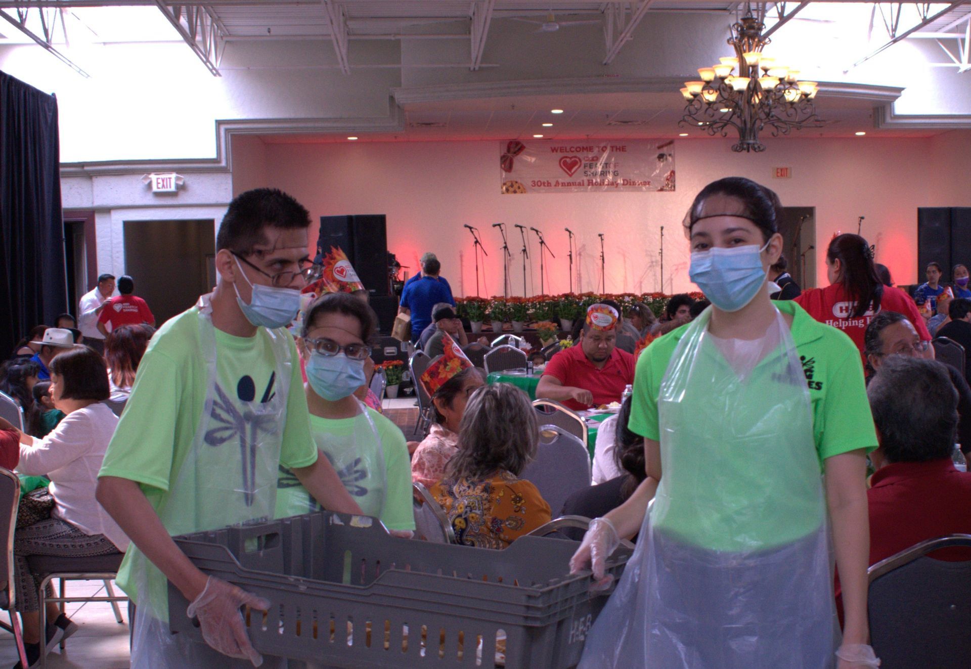 A group of people wearing masks and gloves are standing in a room.