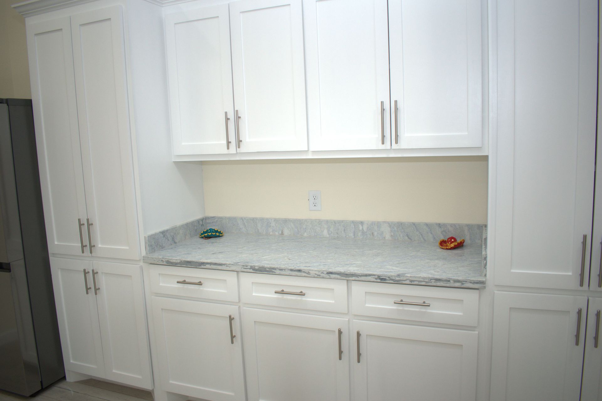 White kitchen cabinets with a granite countertop.