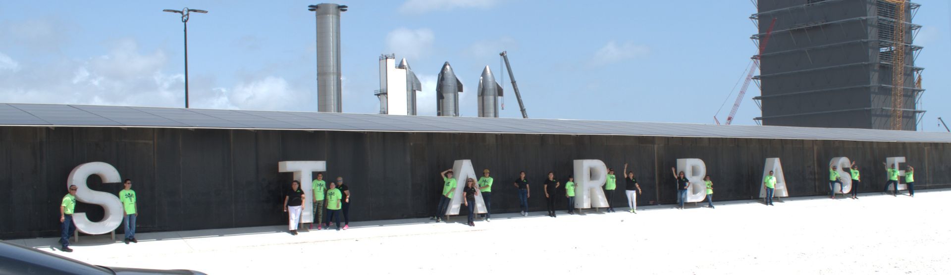 People standing in front of a sign that says starbase