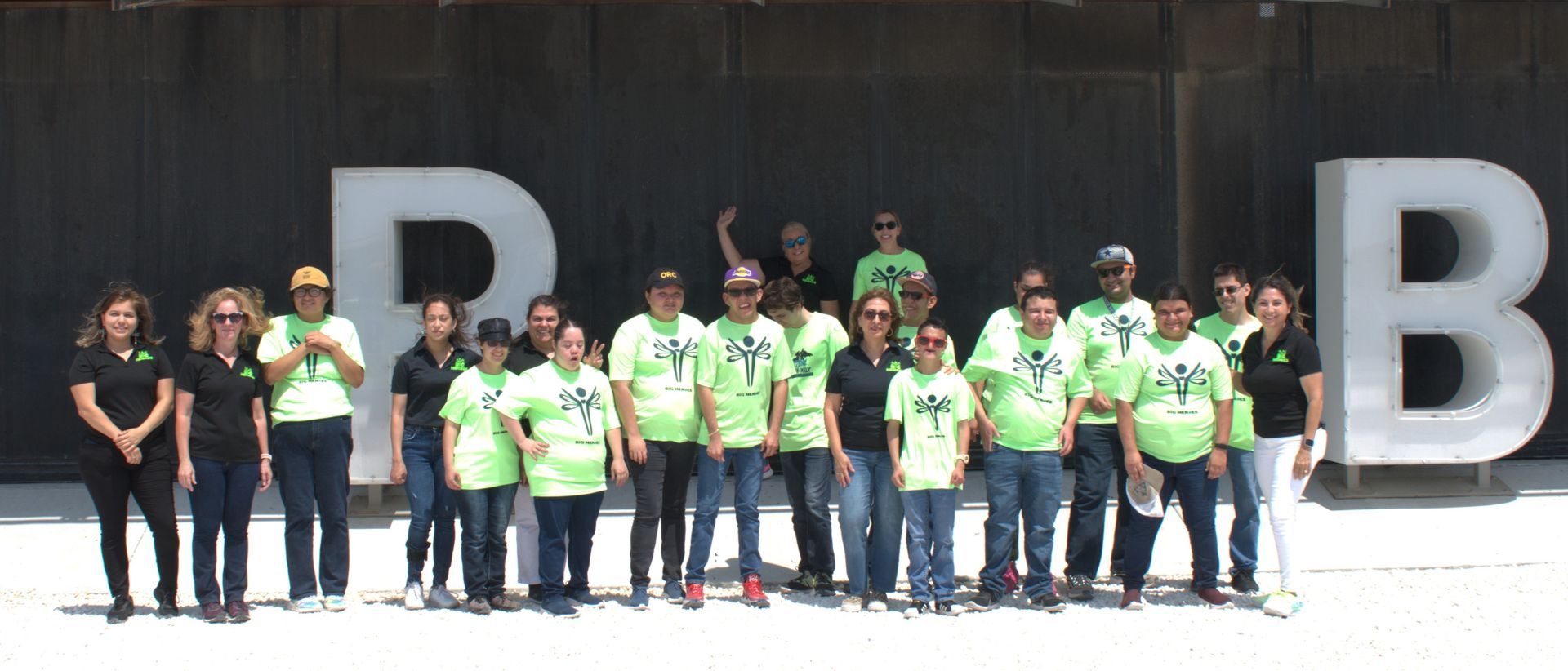 A group of people standing in front of a large letter b