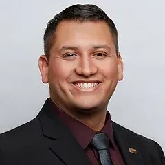A man in a suit and tie is smiling for the camera.