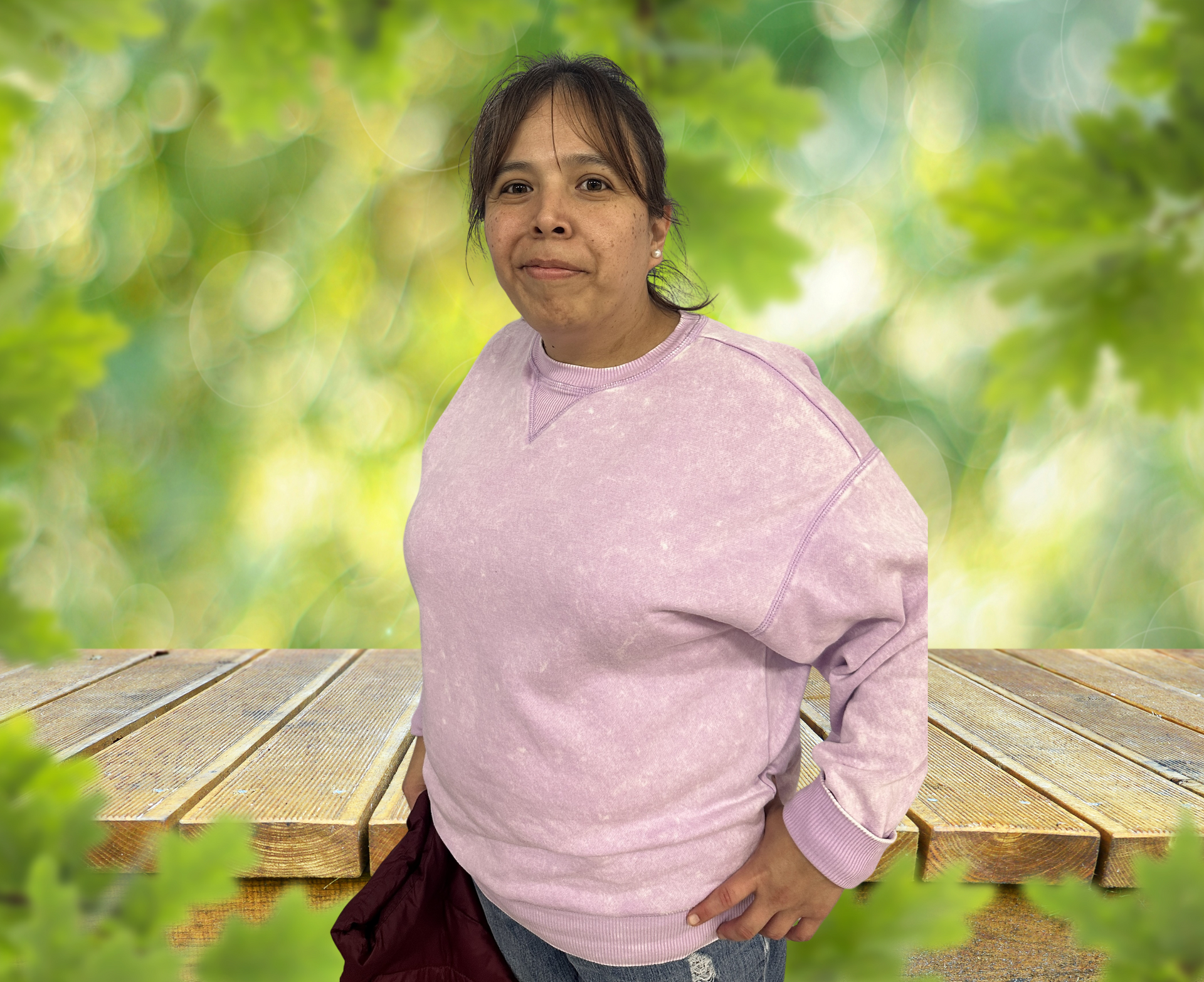 A man in a pink shirt is standing in front of a fence and smiling.