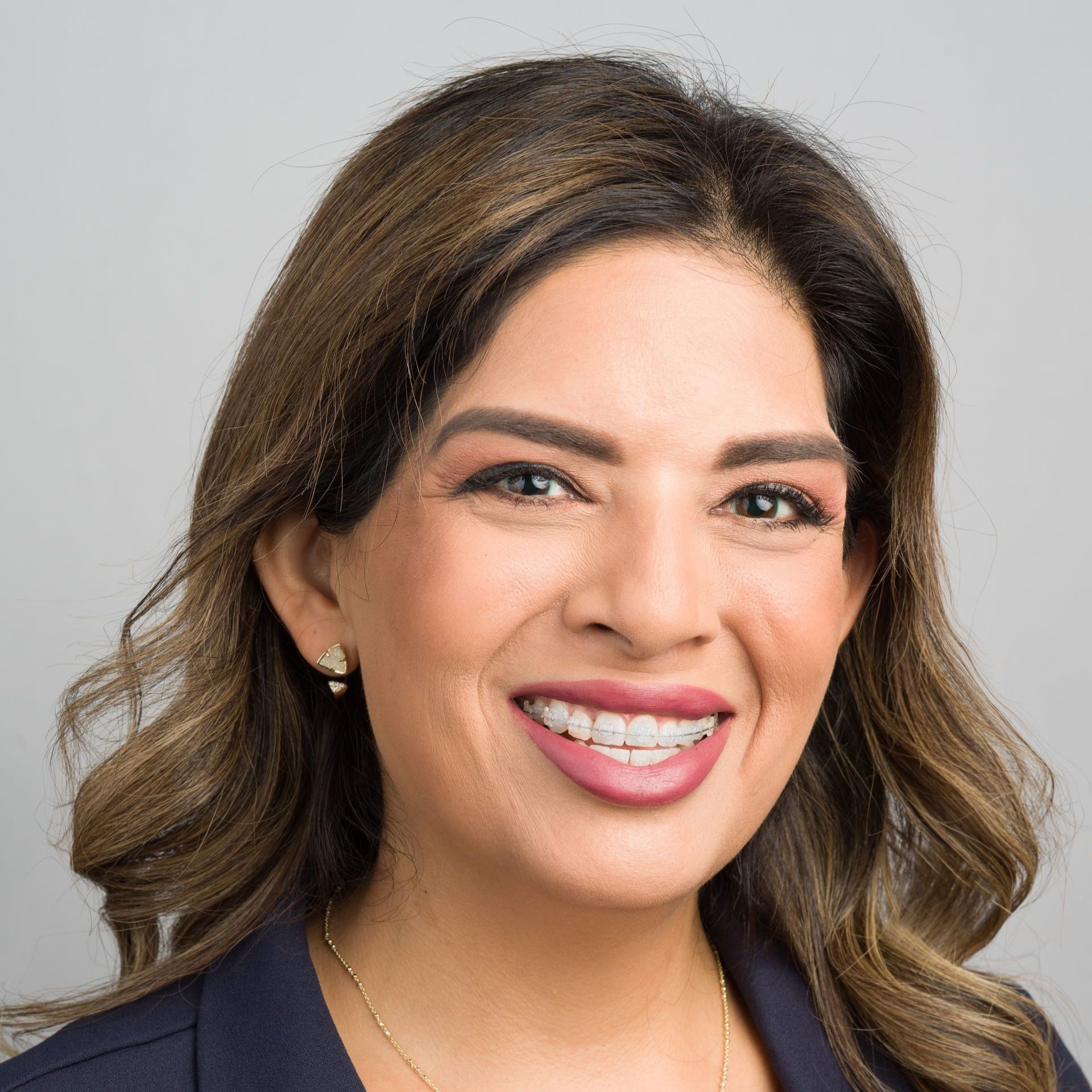 A woman with braces on her teeth is smiling for the camera.