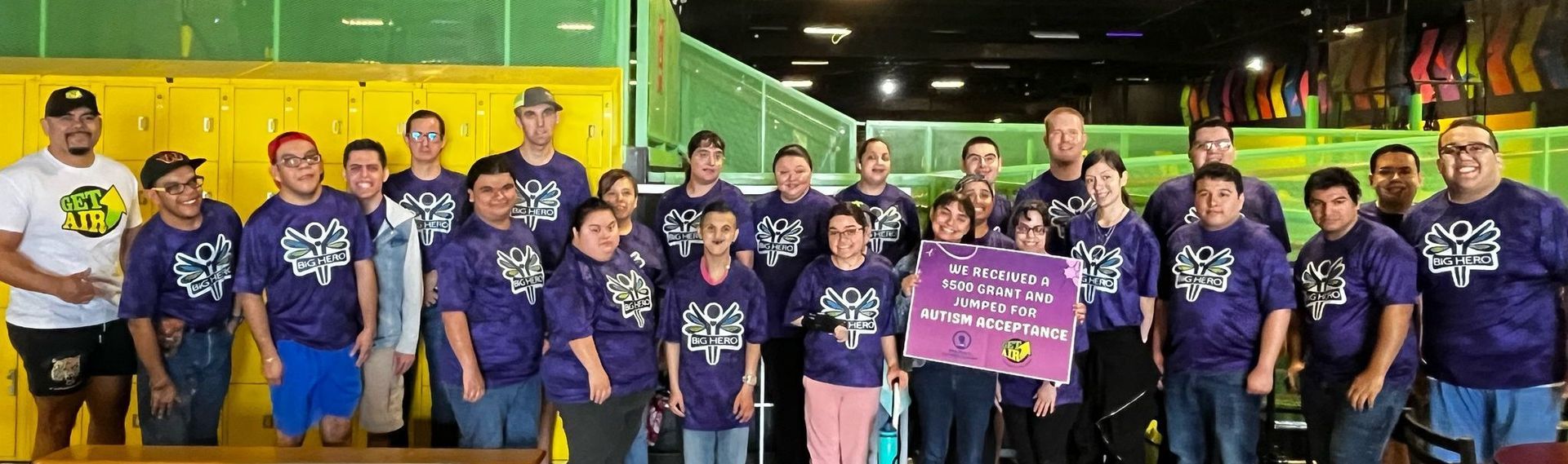 A group of people wearing purple shirts are posing for a picture.