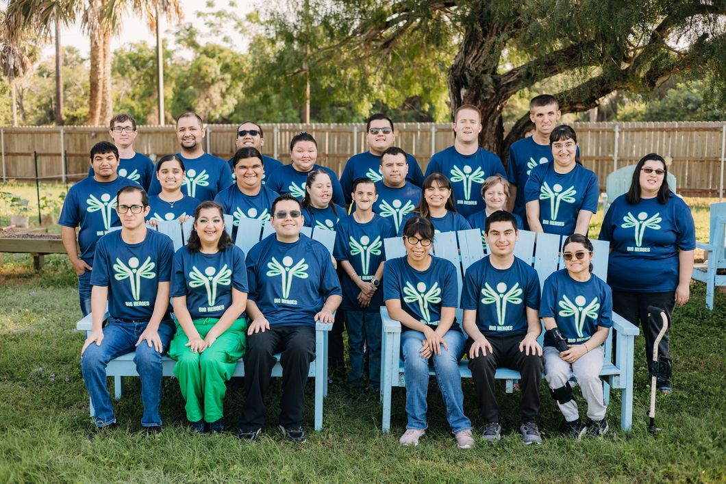 A group of people are posing for a picture in front of a tree.