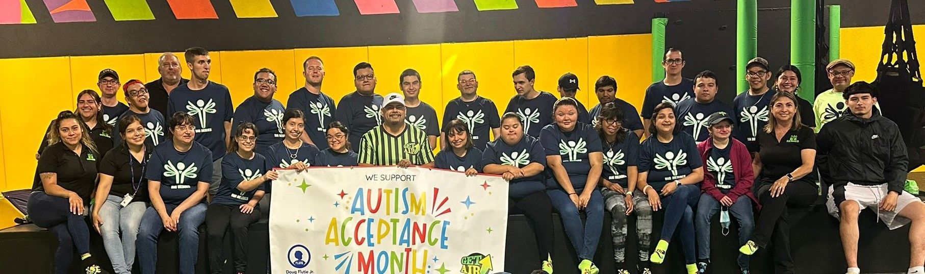 A group of people are posing for a picture while holding a sign.