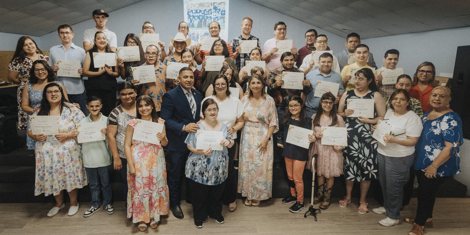Group photo of people holding certificates, likely a graduation ceremony.