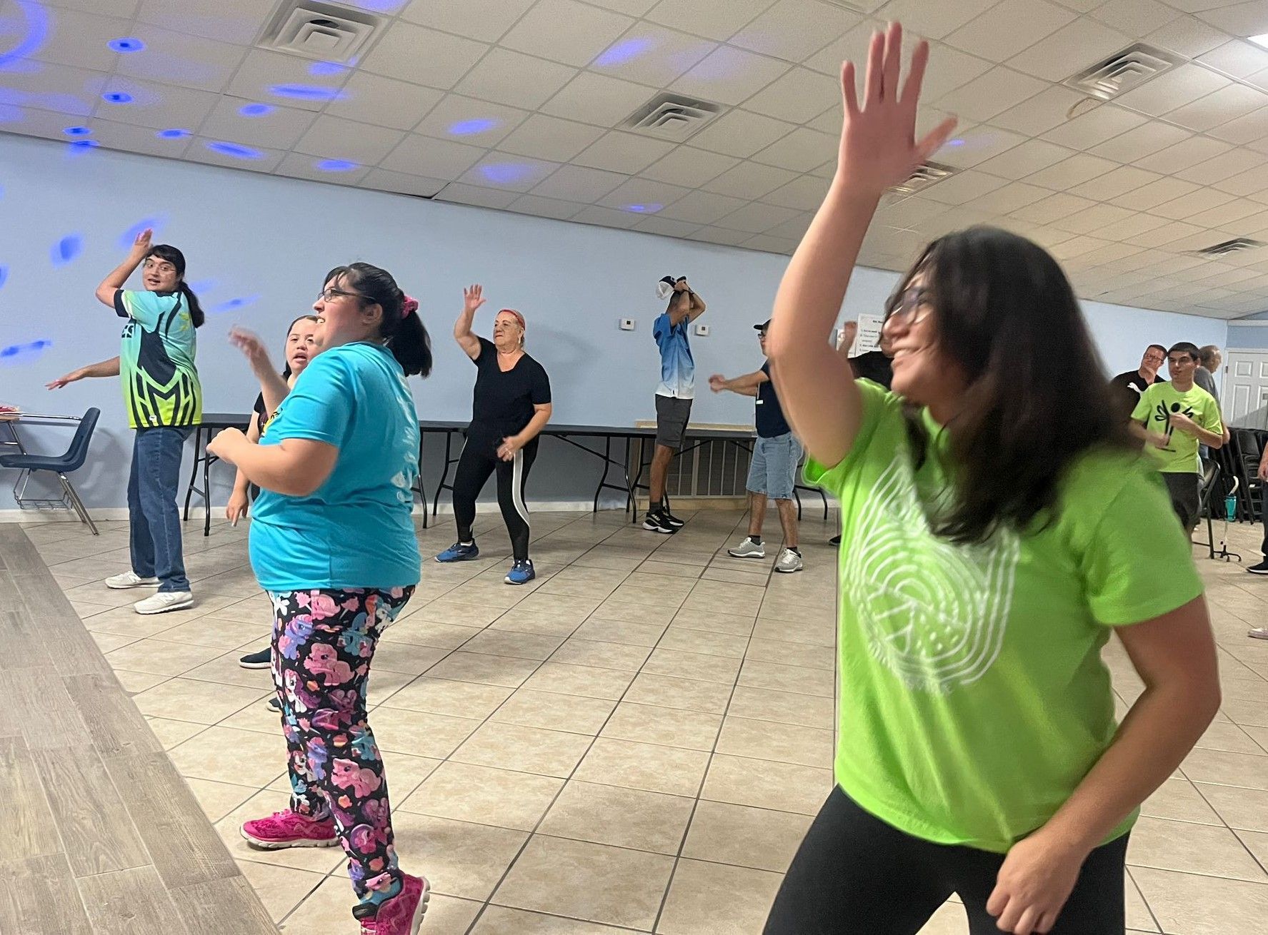 A group of people are dancing in a room.