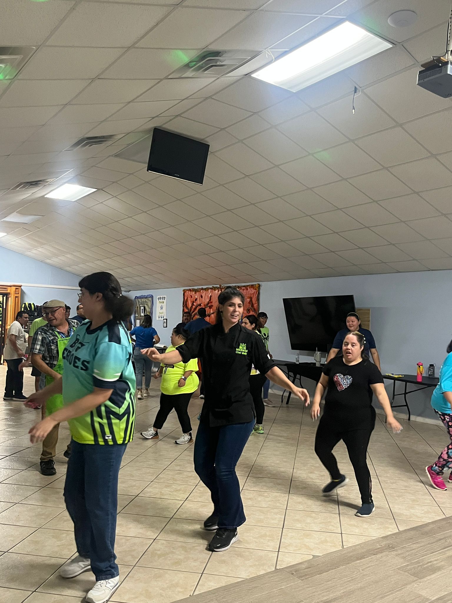 A group of people are dancing in a room.