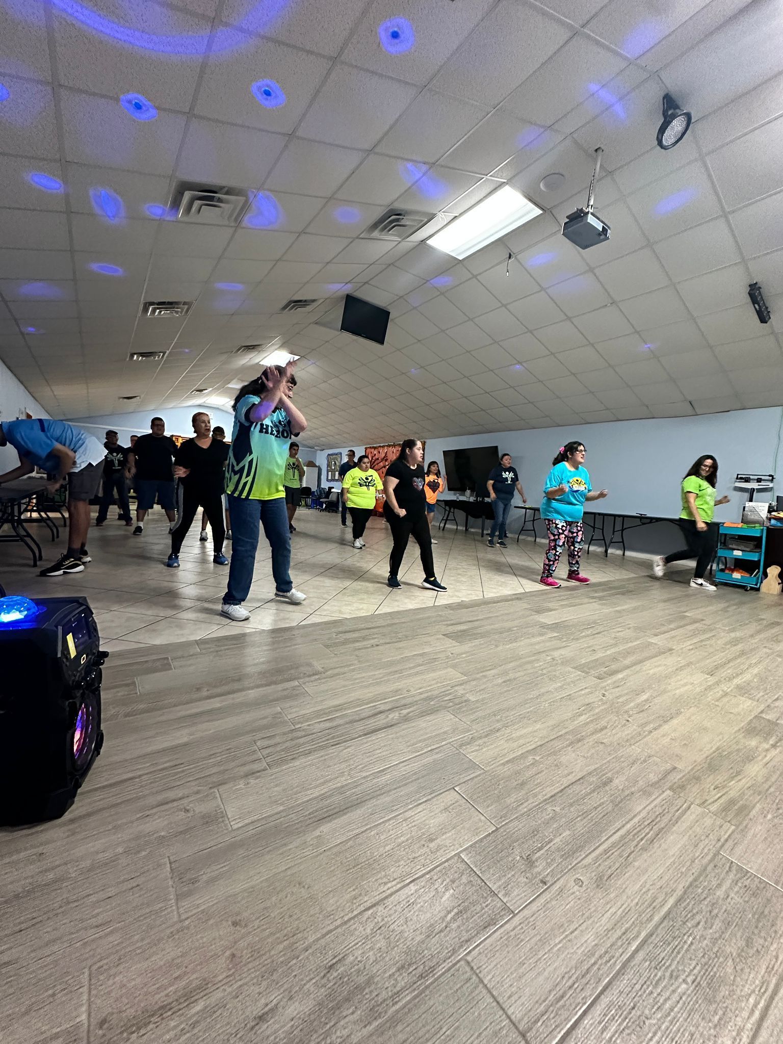 A group of people are dancing in a large room.