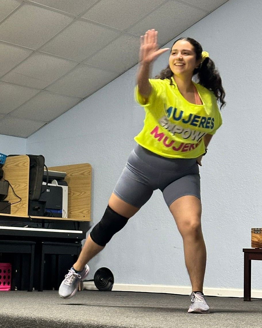 A woman wearing a yellow shirt that says mujeres