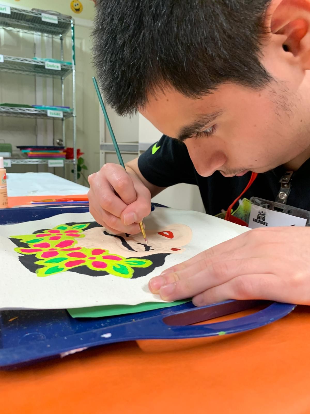 A man is painting on a piece of paper with a brush