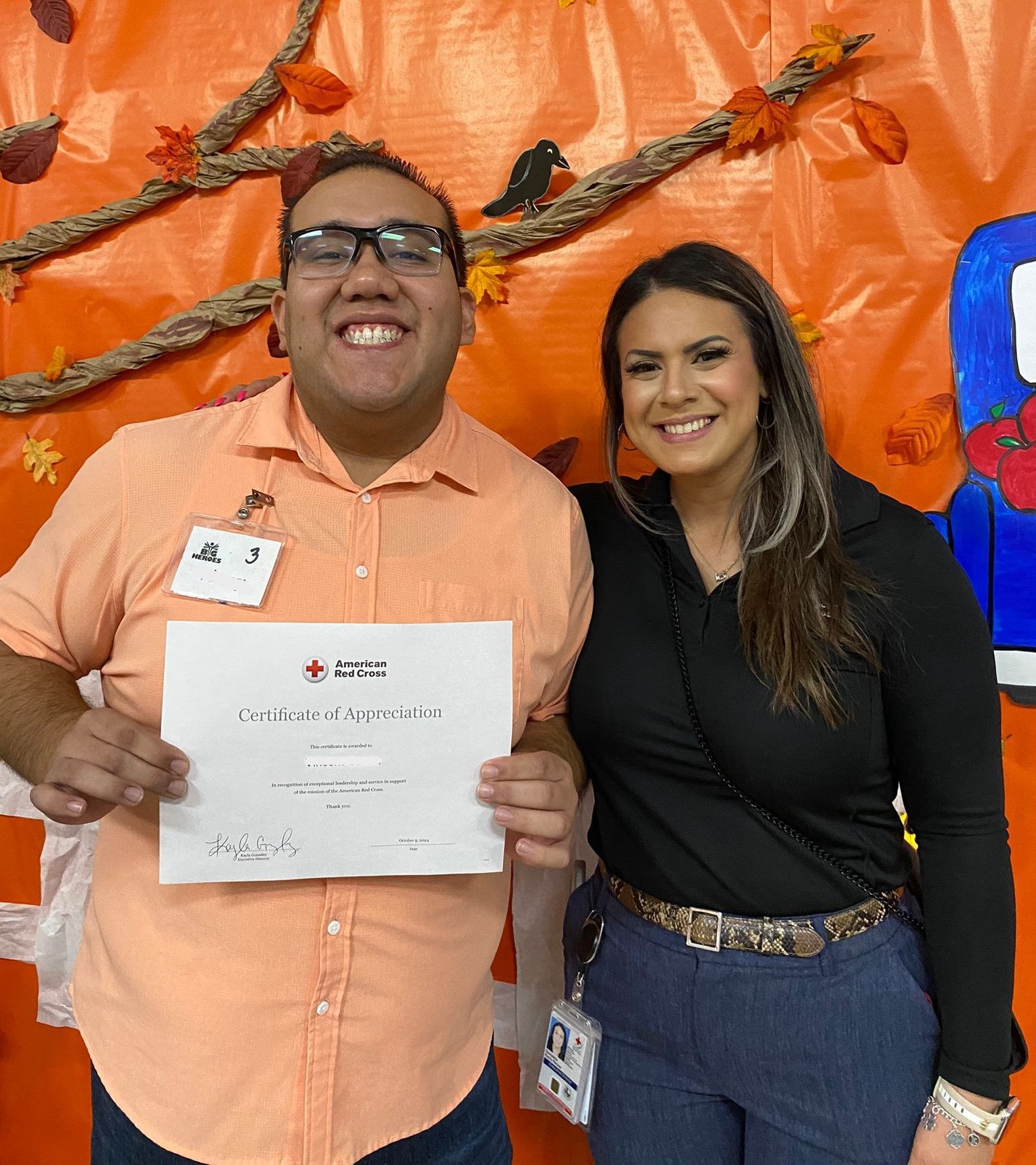 A man and a woman are posing for a picture and the man is holding a certificate
