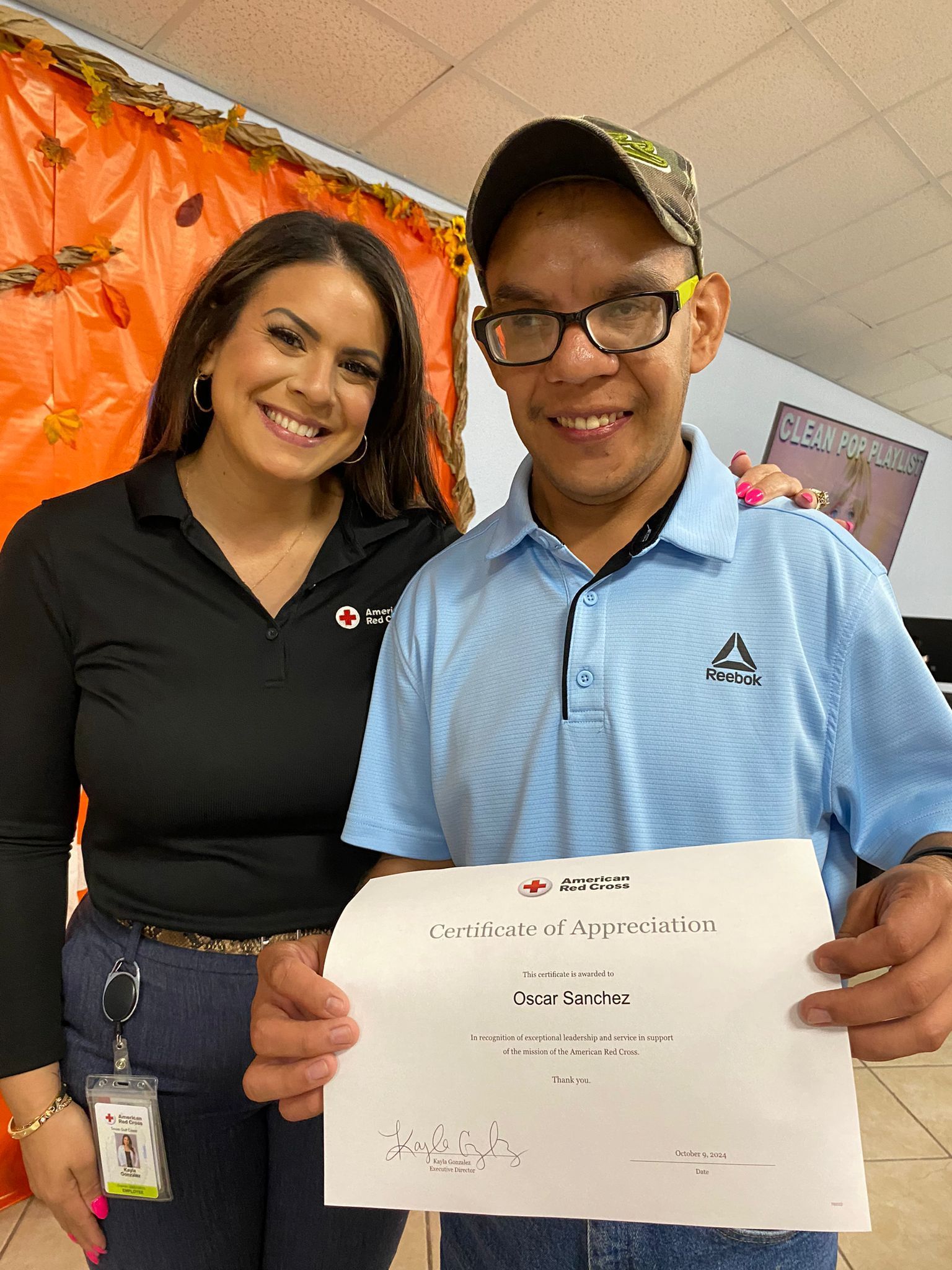 A man and a woman are standing next to each other holding a certificate.