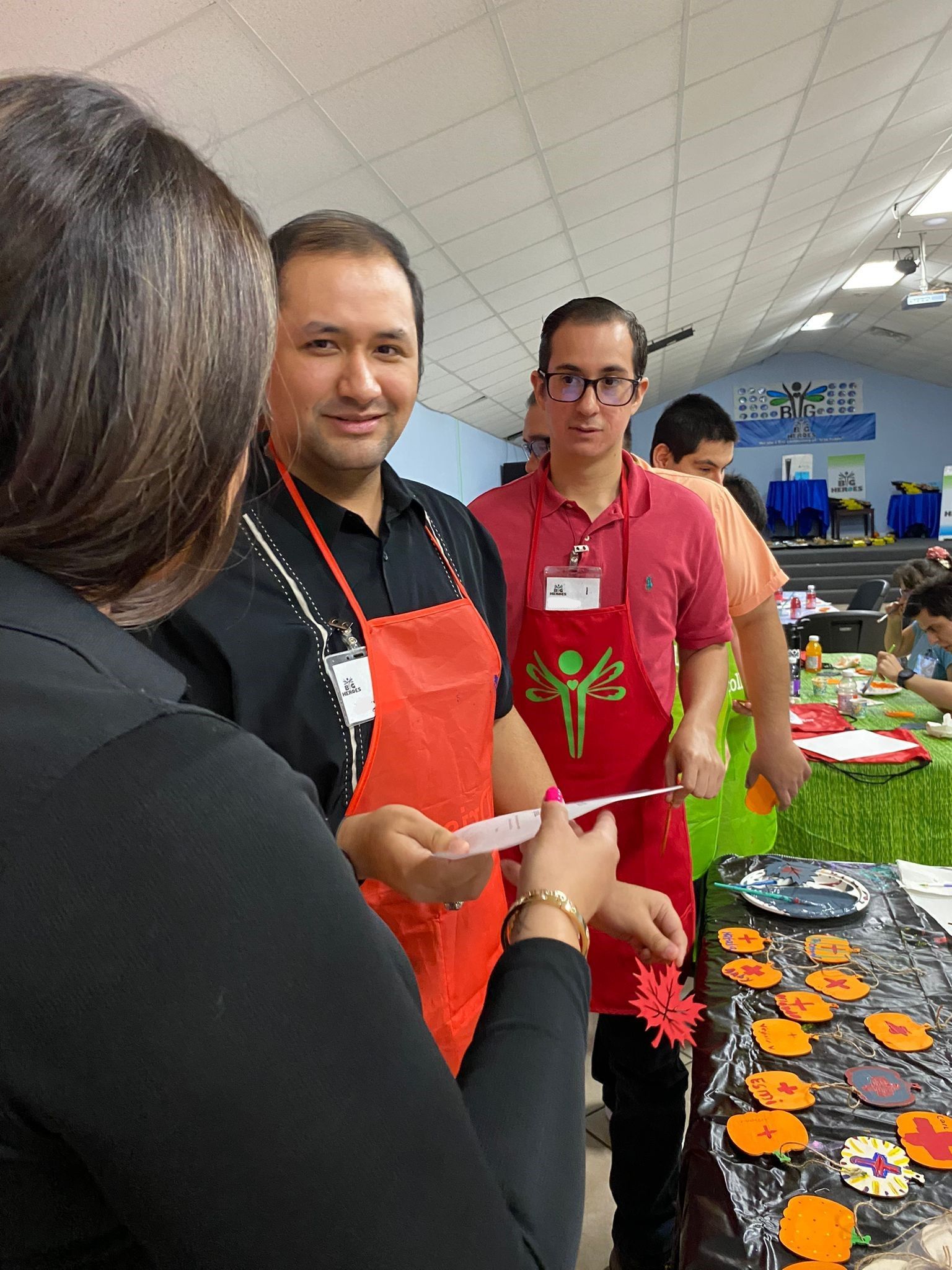 A group of people wearing aprons are standing around a table.