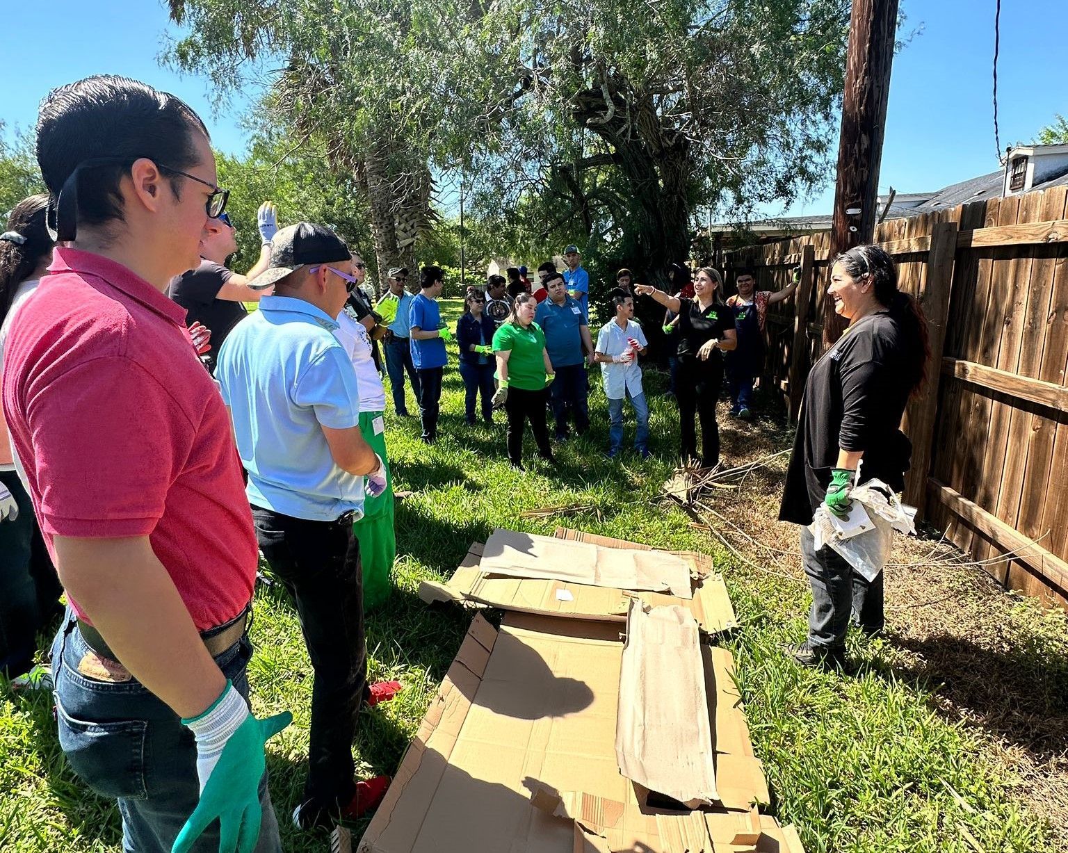 A group of people are standing around a pile of cardboard boxes.
