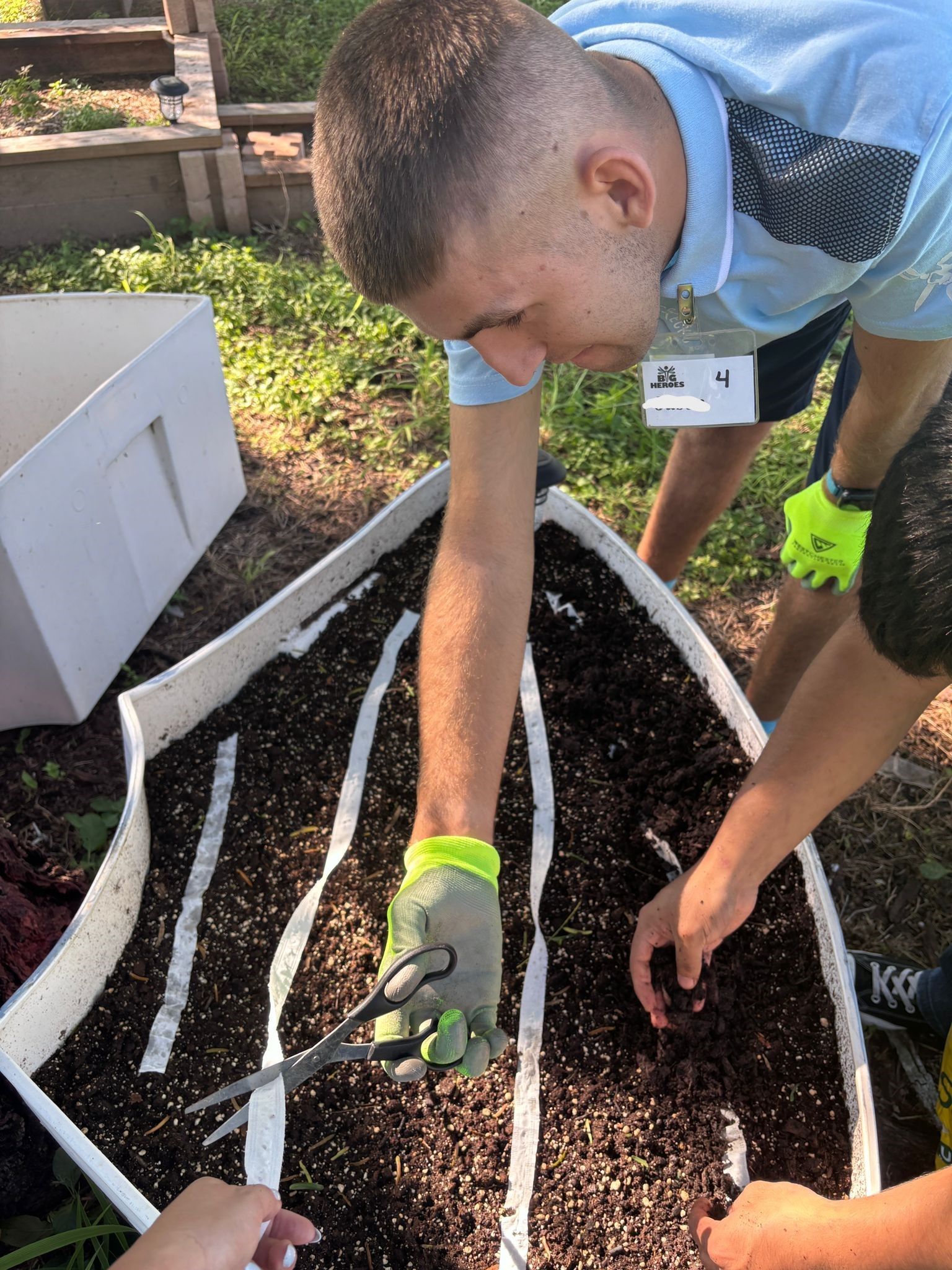 A man is planting a plant in a garden.