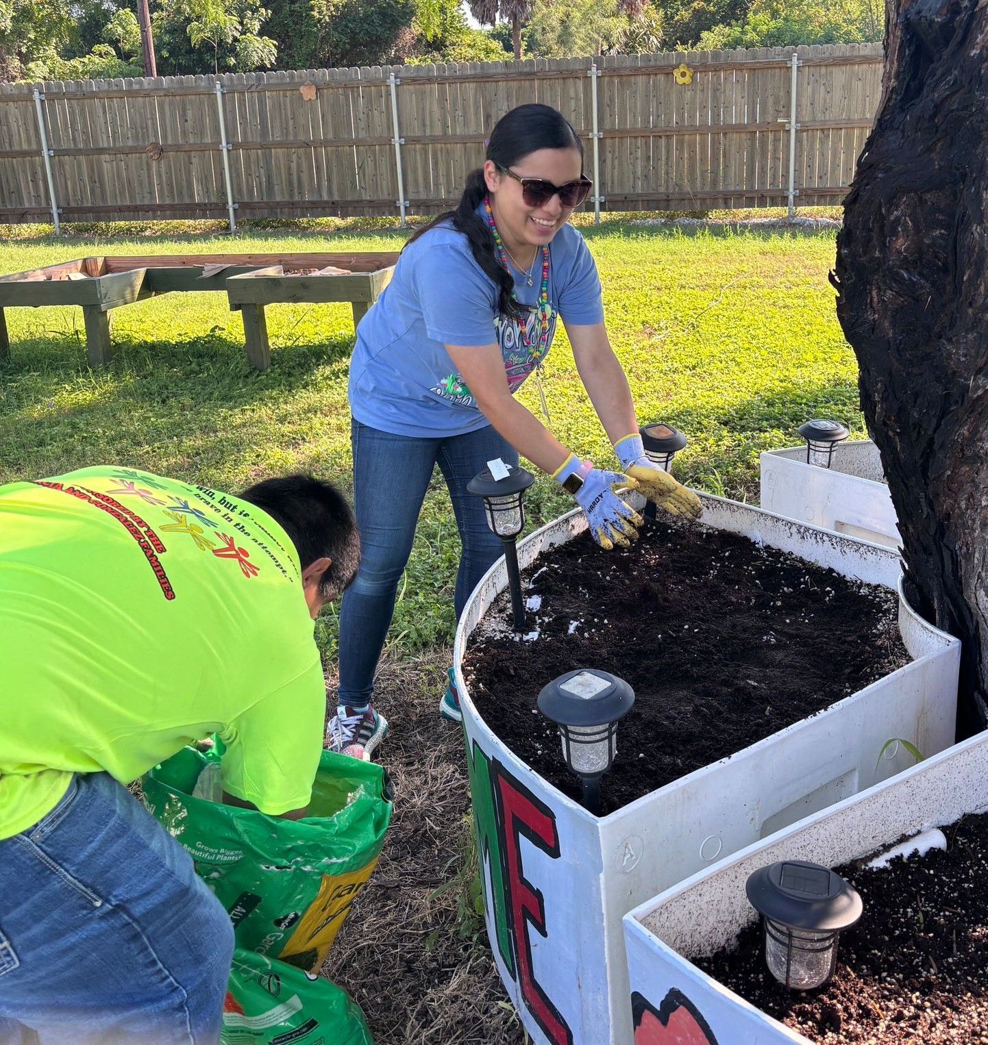 A man and a woman are working in a garden