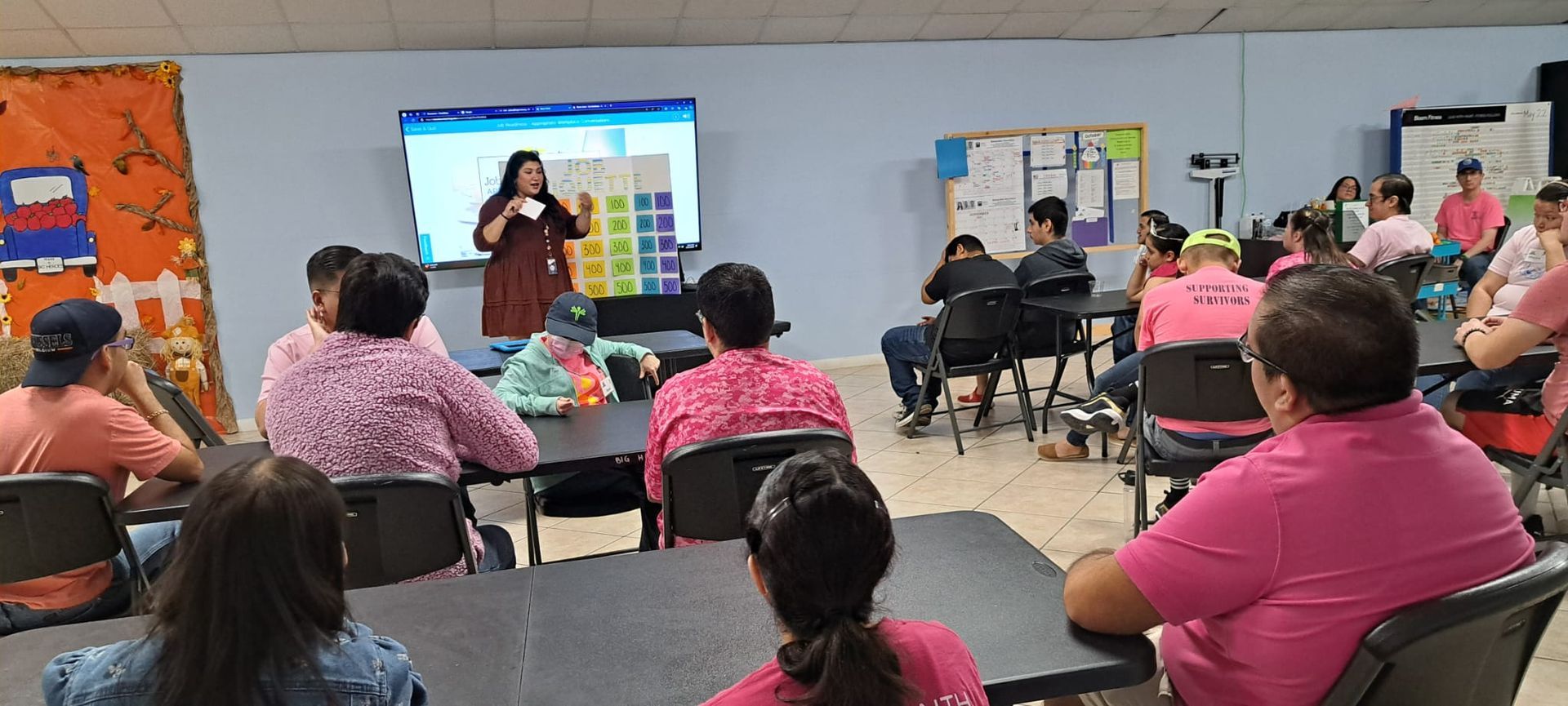 A woman is giving a presentation to a group of people in a classroom.