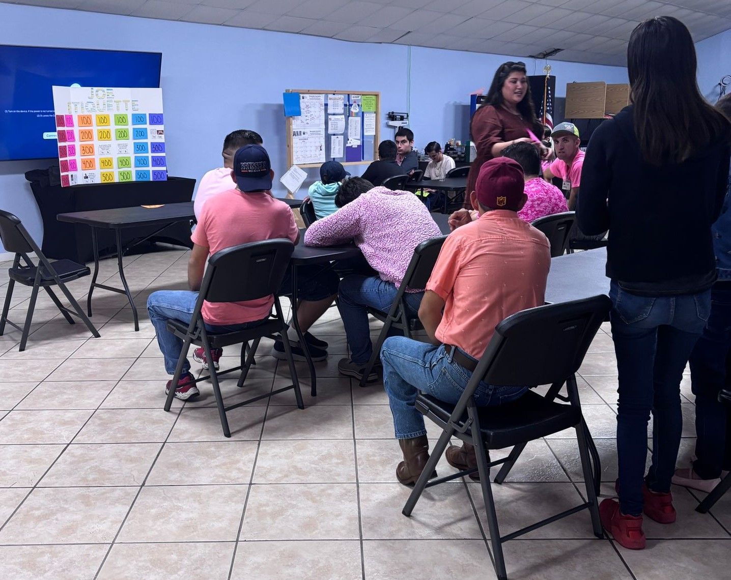 A group of people are sitting in folding chairs in a room