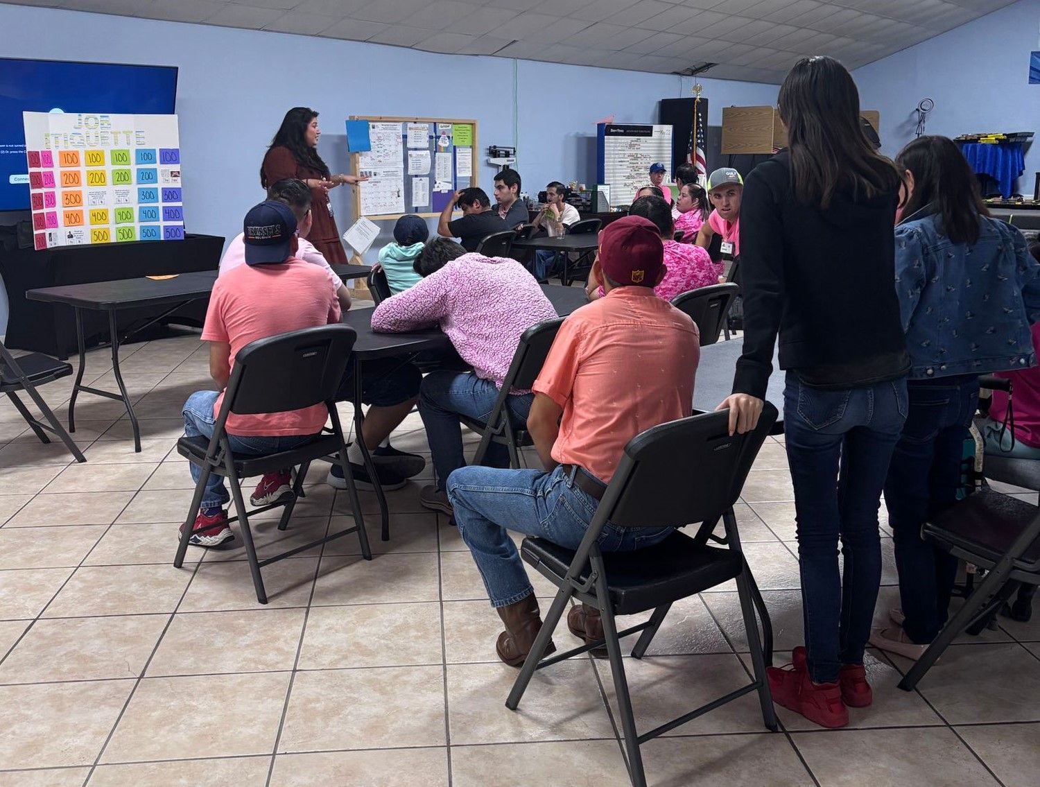 A group of people are sitting in folding chairs in a room.