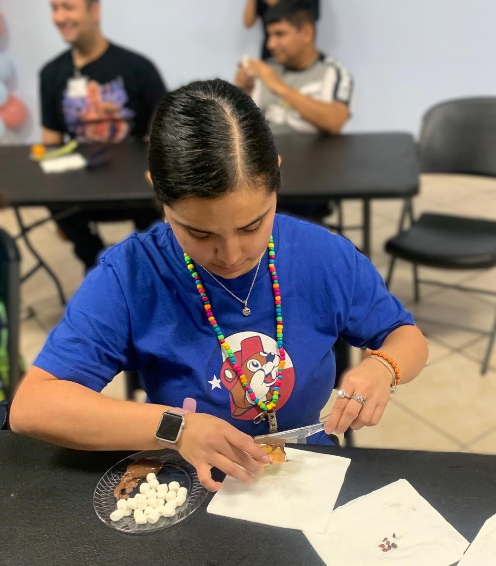A woman in a blue shirt is sitting at a table with a plate of pills on it