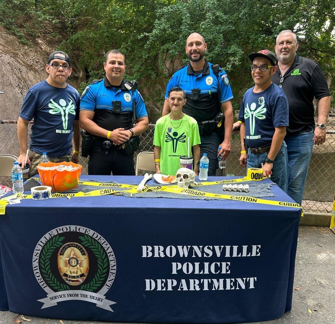 A group of police officers standing around a table that says brownsville police department