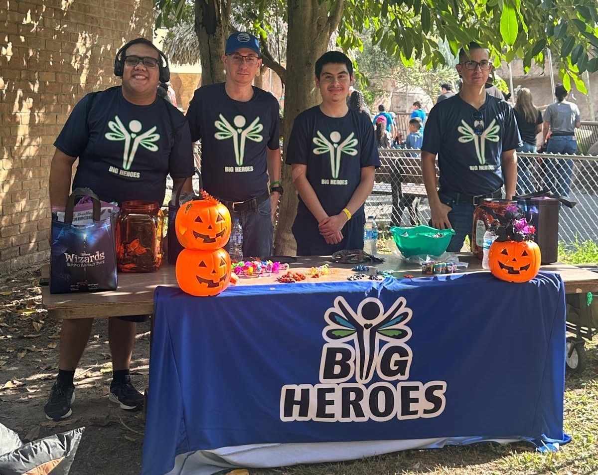 A group of people standing around a table that says big heroes