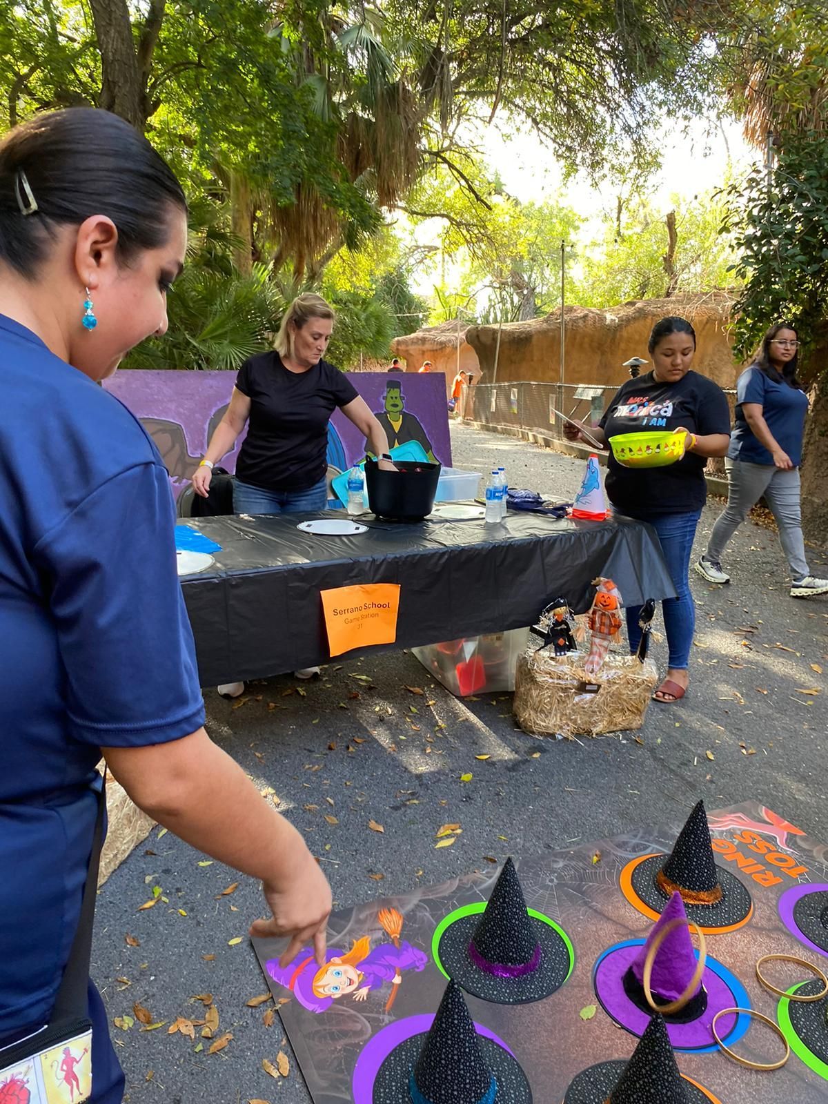 A group of women are playing a game with witch hats.