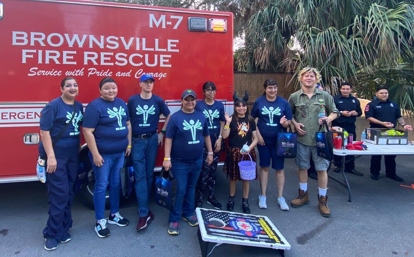 A group of people standing in front of a brownsville fire rescue truck