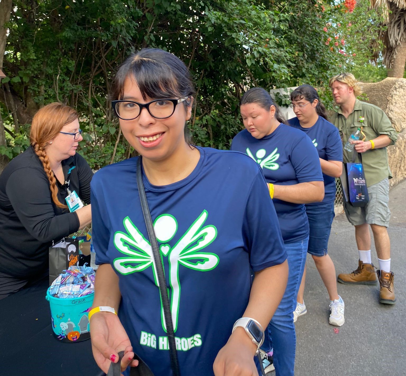 A woman wearing a blue shirt with a dragonfly on it