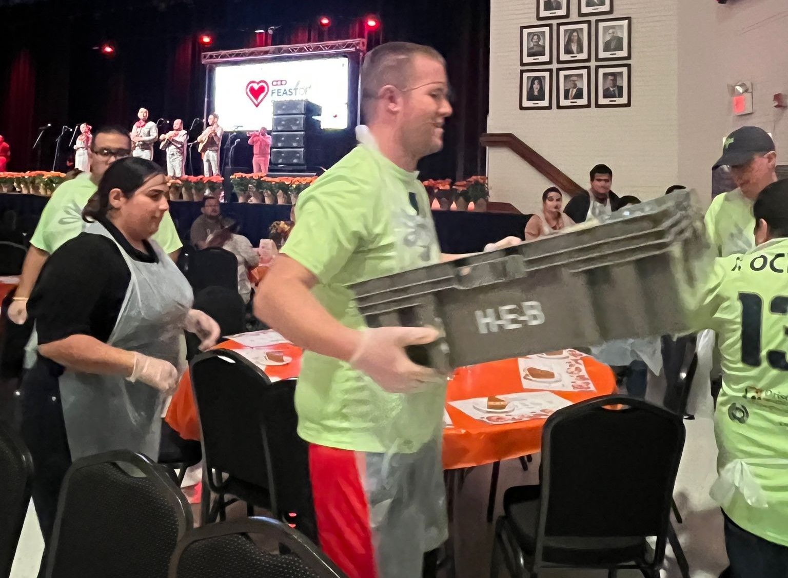 A man is carrying a crate that says heb on it
