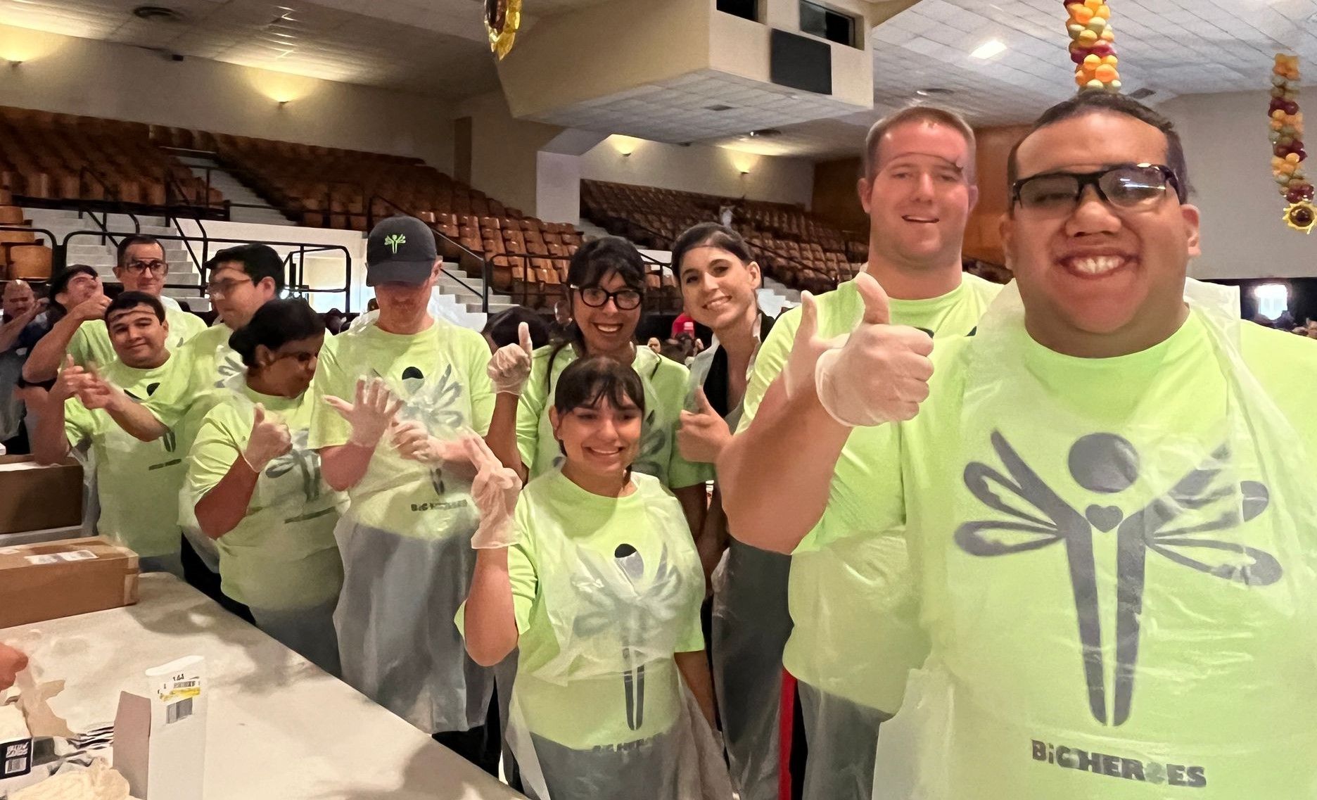 A group of people are standing in a line giving thumbs up.