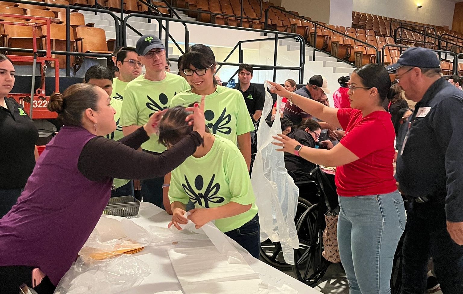 A group of people are standing around a table in a stadium.