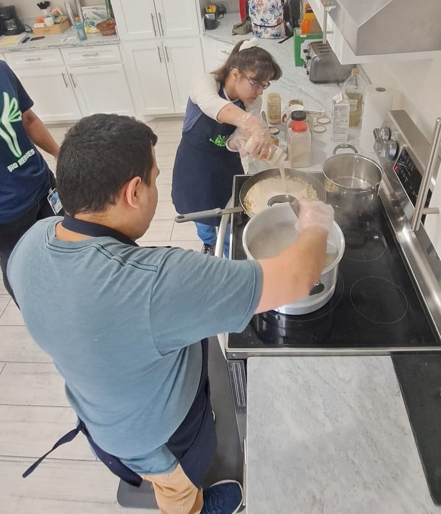 A man is pouring liquid into a pot on a stove