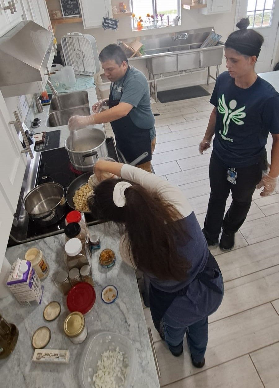 A group of people are standing in a kitchen preparing food.