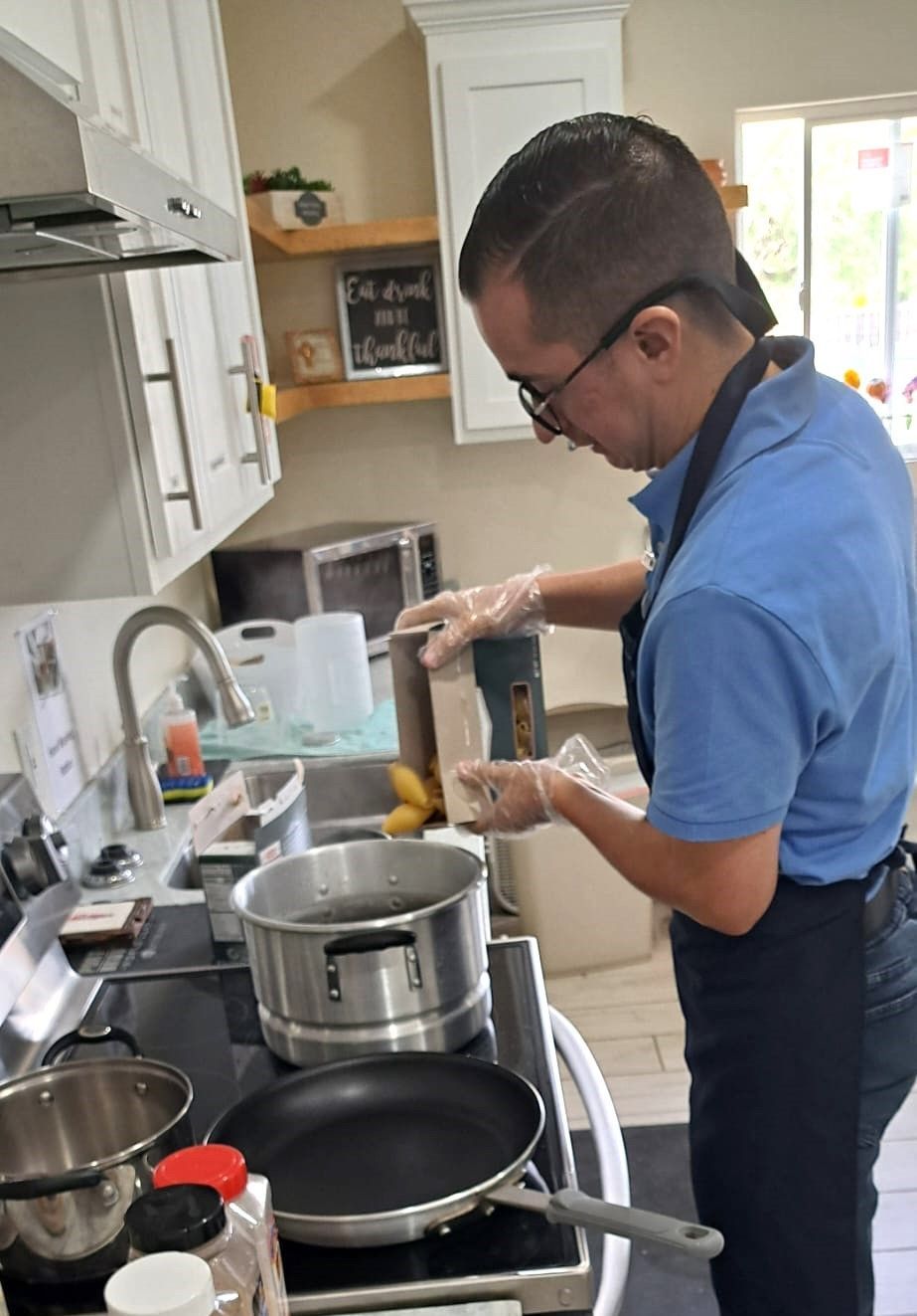 A man in a blue shirt is cooking in a kitchen