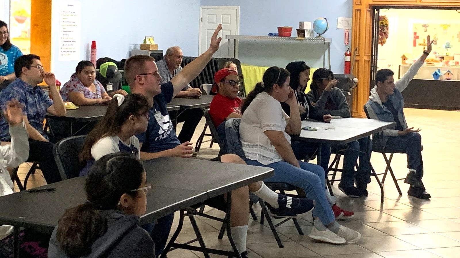 A group of people are sitting at tables in a room.