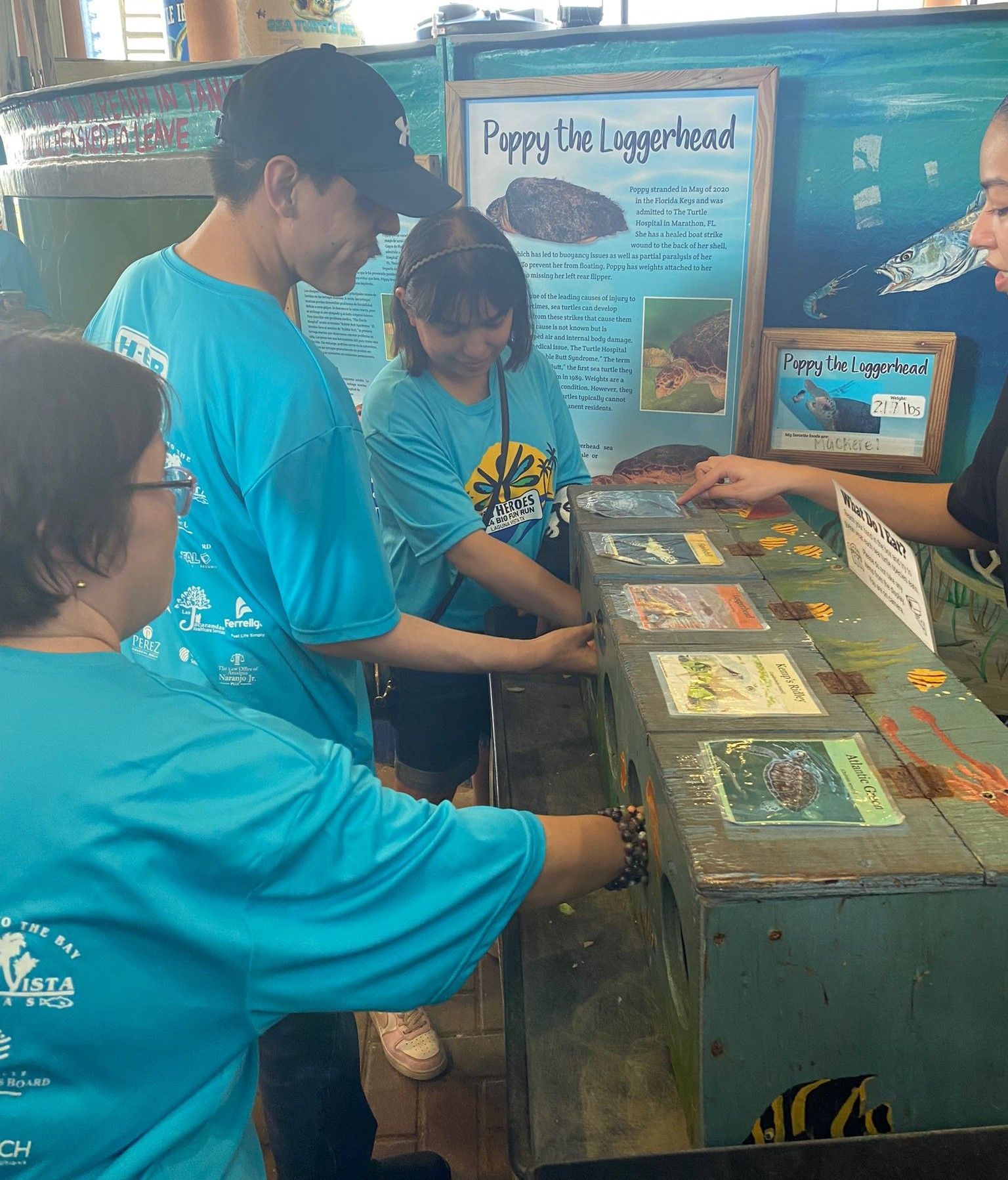 A group of people standing around a table with a sign that says puppy the lizardhead