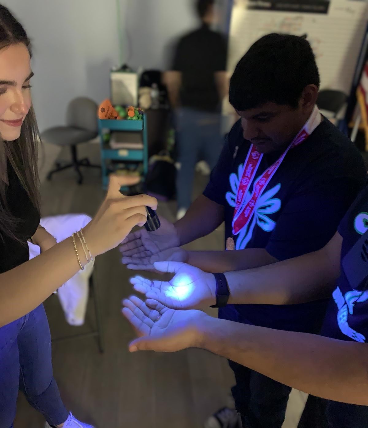 A group of people are holding glow in the dark objects in their hands