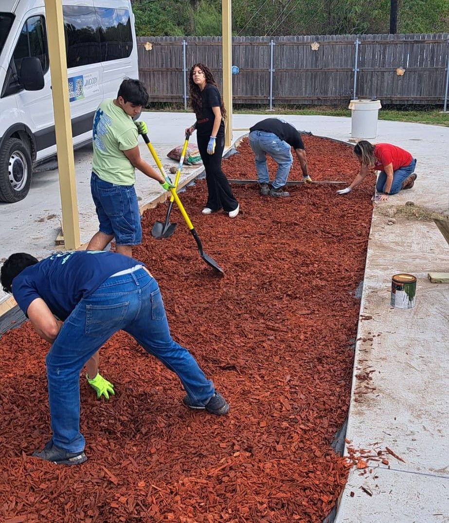 A group of people are working in a pile of mulch.